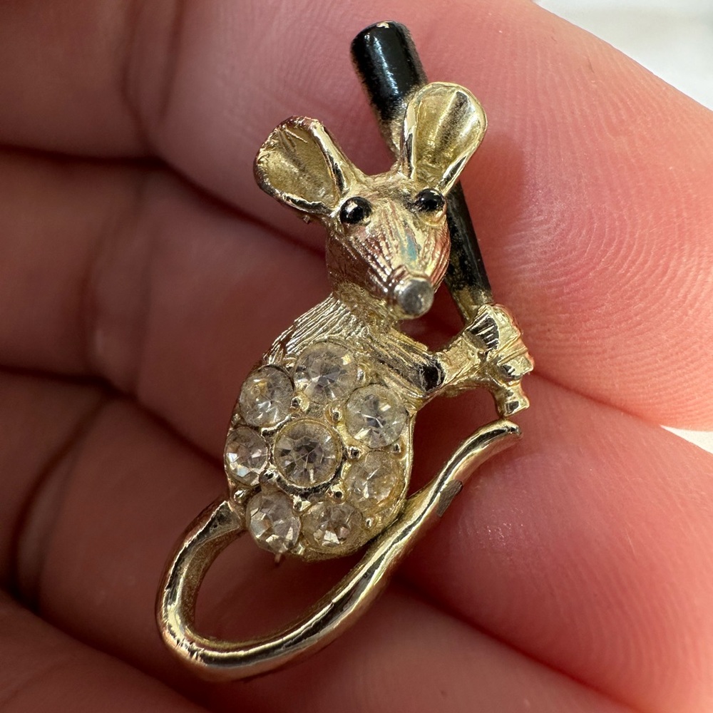 Tiny vintage mouse pin holding baseball bat